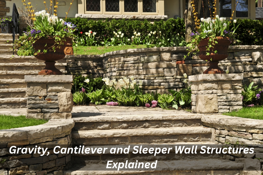 Multi-tiered natural stone retaining wall and stone steps surrounded by spring flowers and urn planters