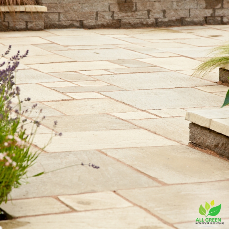 Elegant travertine paving in a landscaped garden with lavender plants and natural stone accents, creating a stylish outdoor space.