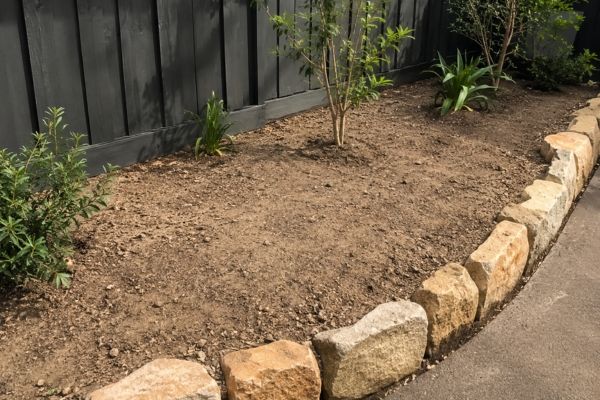 Bare, dry Sydney garden bed with exposed soil before mulching