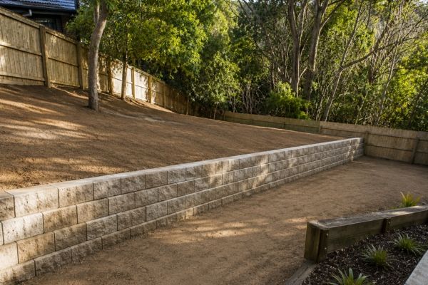 Same backyard levelled and held by a new retaining wall, ready for turf